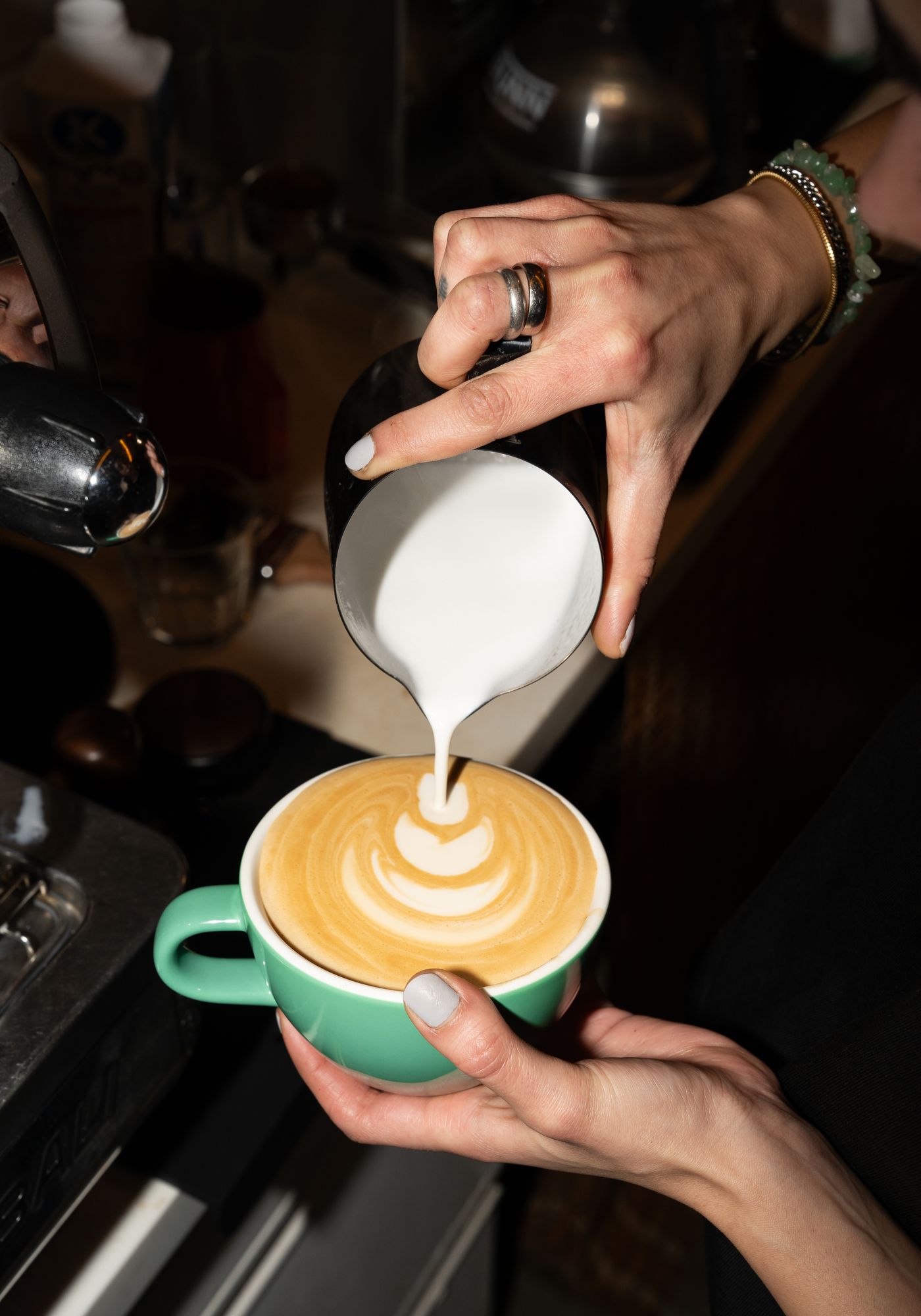 Baristanın süt dökerek latte art yaptığı an
