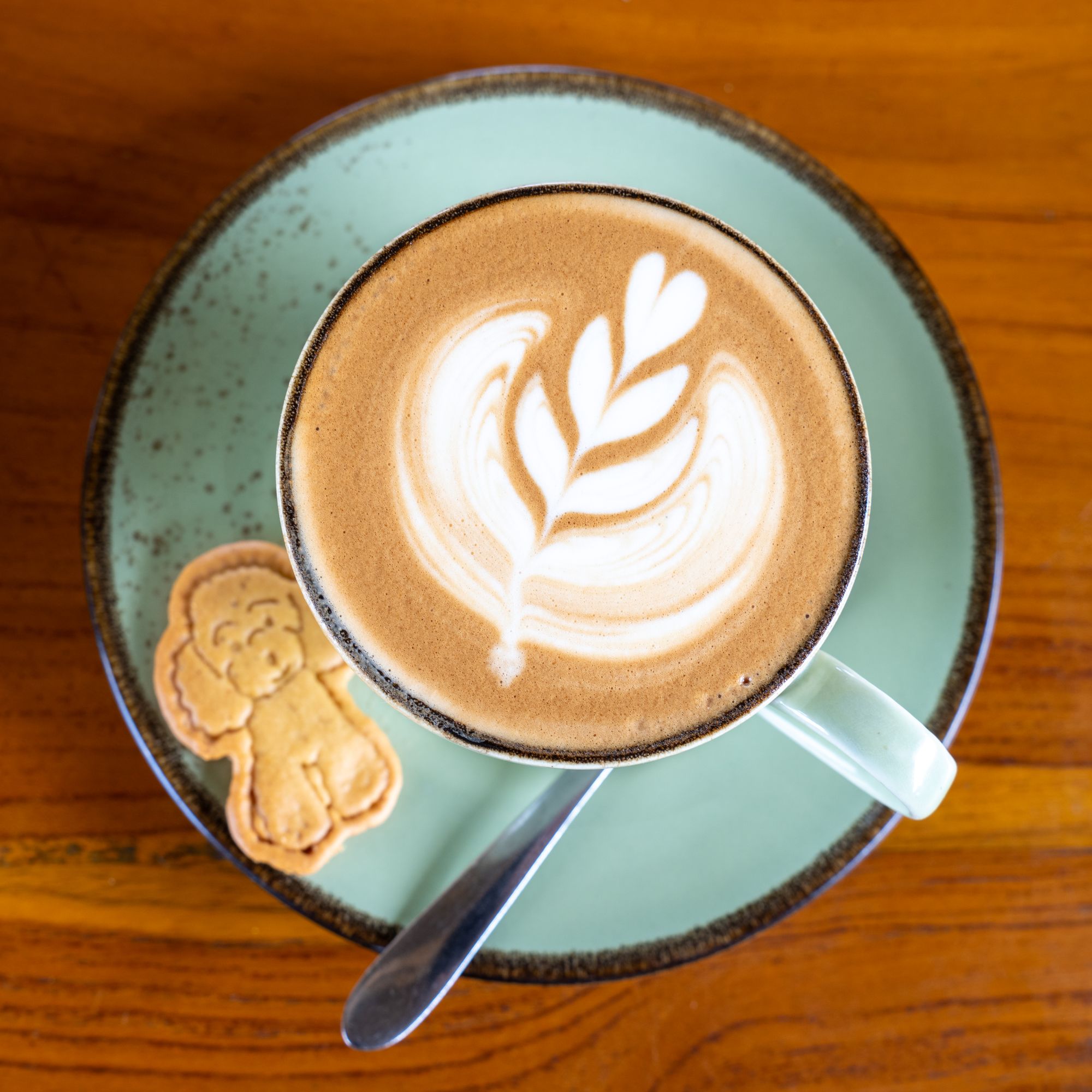 Üstten çekilmiş latte ve yanında kurabiye