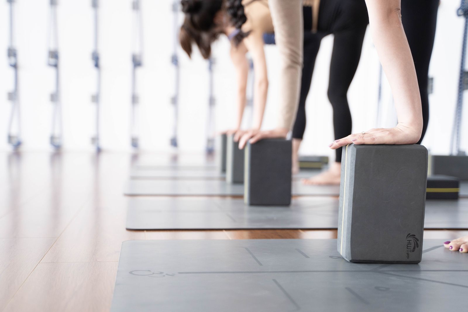 Yoga bloklarıyla esneme yapan bir grup, yakın plan