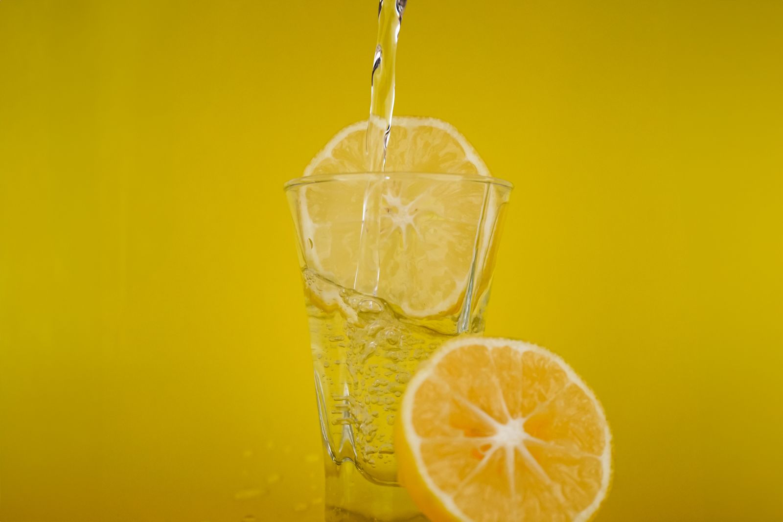 Sarı zeminde limonlu bir bardak su