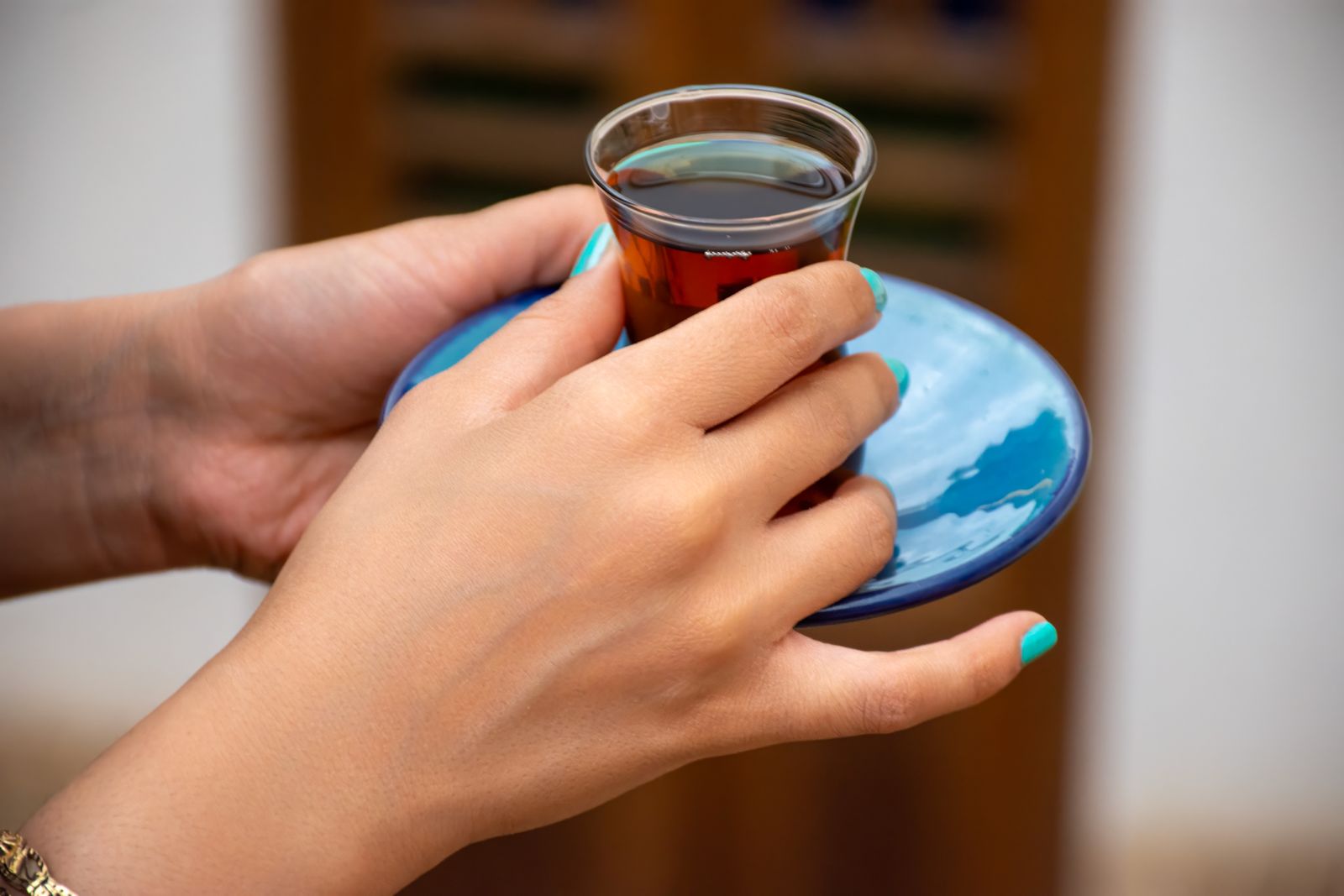 İnce belli bardakta çay tutan el