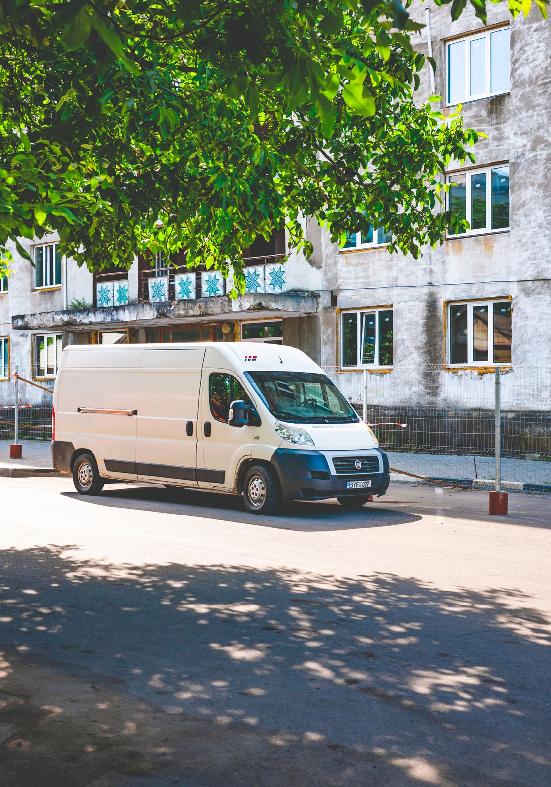 Sokakta park etmiş beyaz bir servis aracı