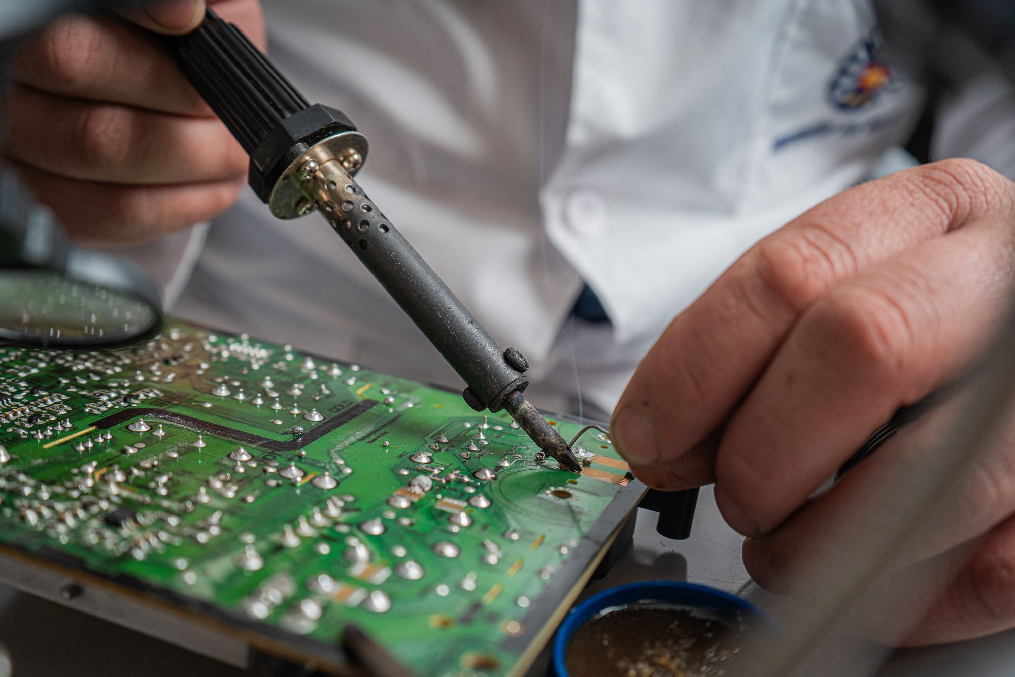 Bir elektronik kartı lehimleyen teknisyen elleri