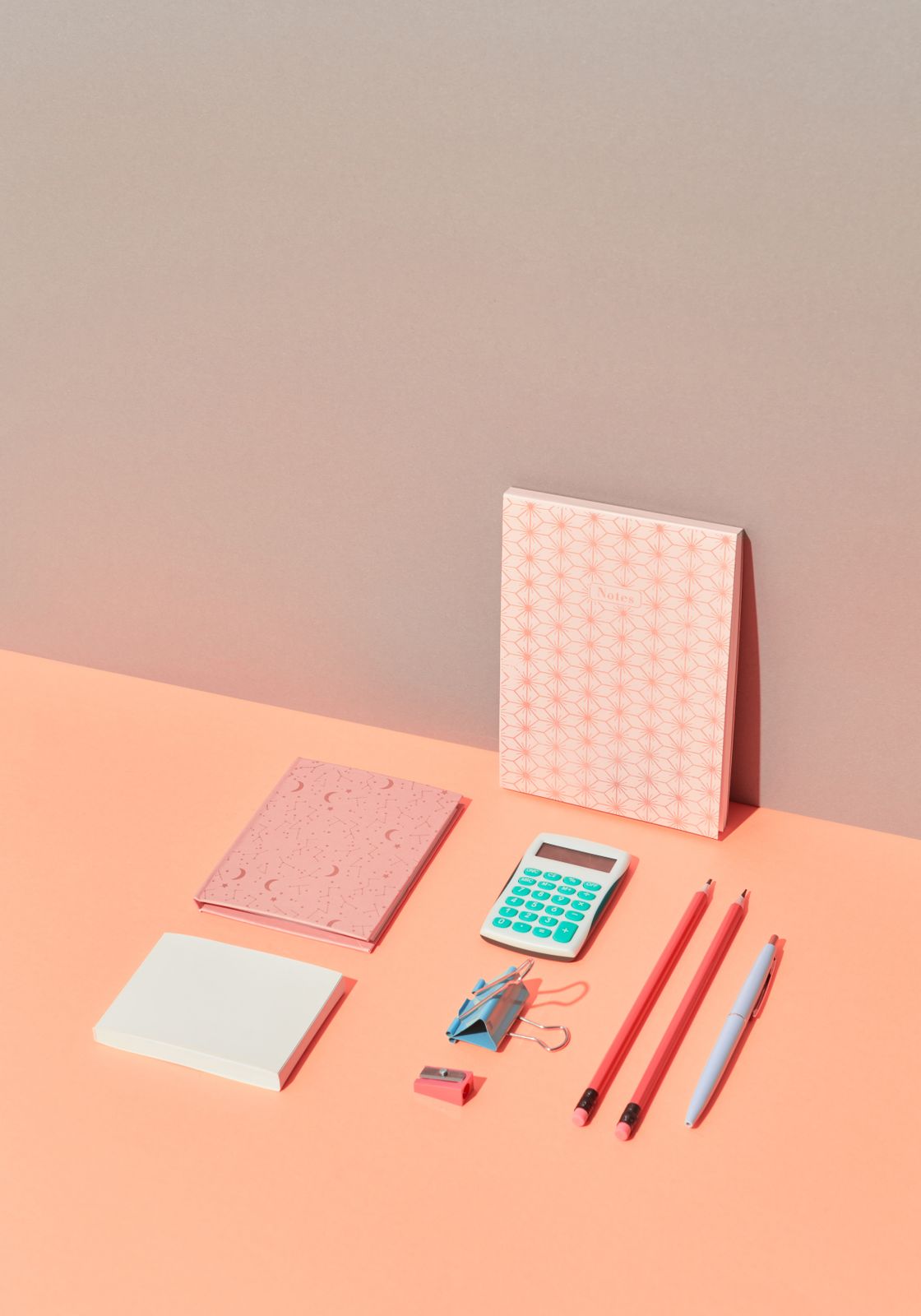 Pastel zeminde defter, kalem ve hesap makinesi