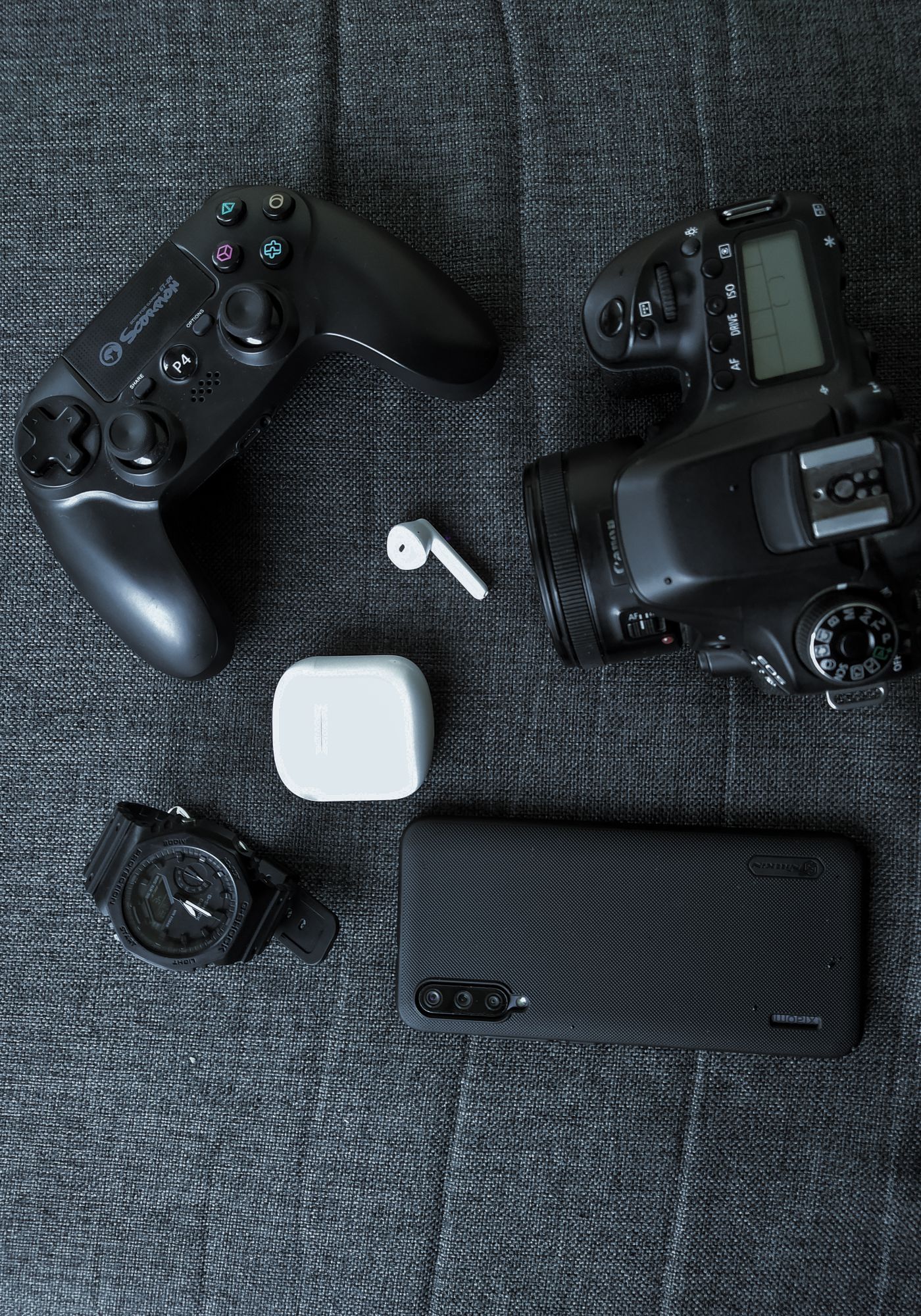 Koyu zeminde oyun kumandası, fotoğraf makinesi ve telefon