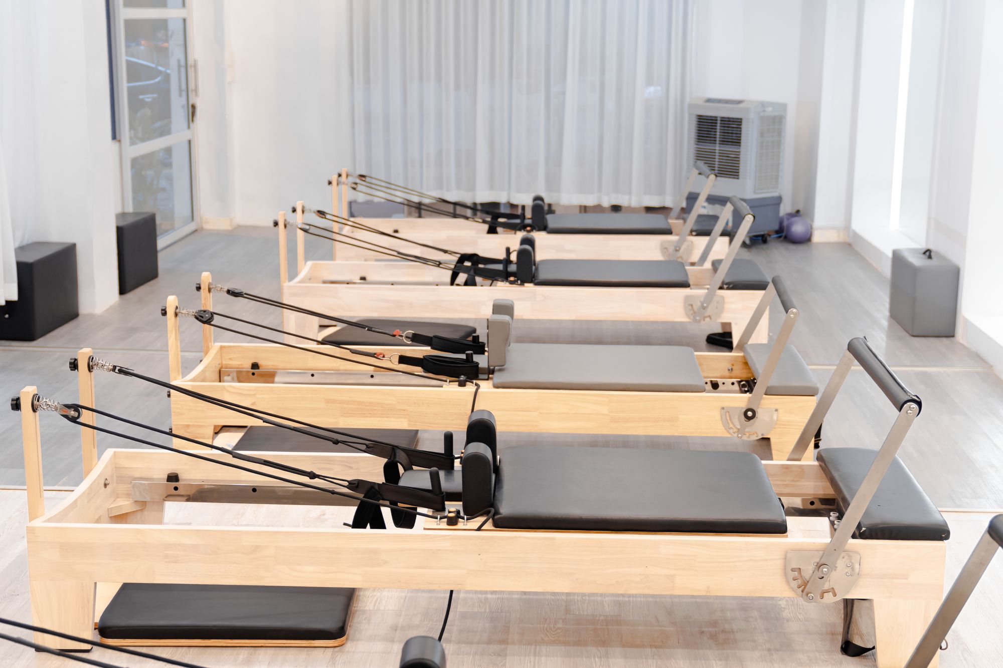 Perdeli pencerelerden gün ışığı alan pilates salonu