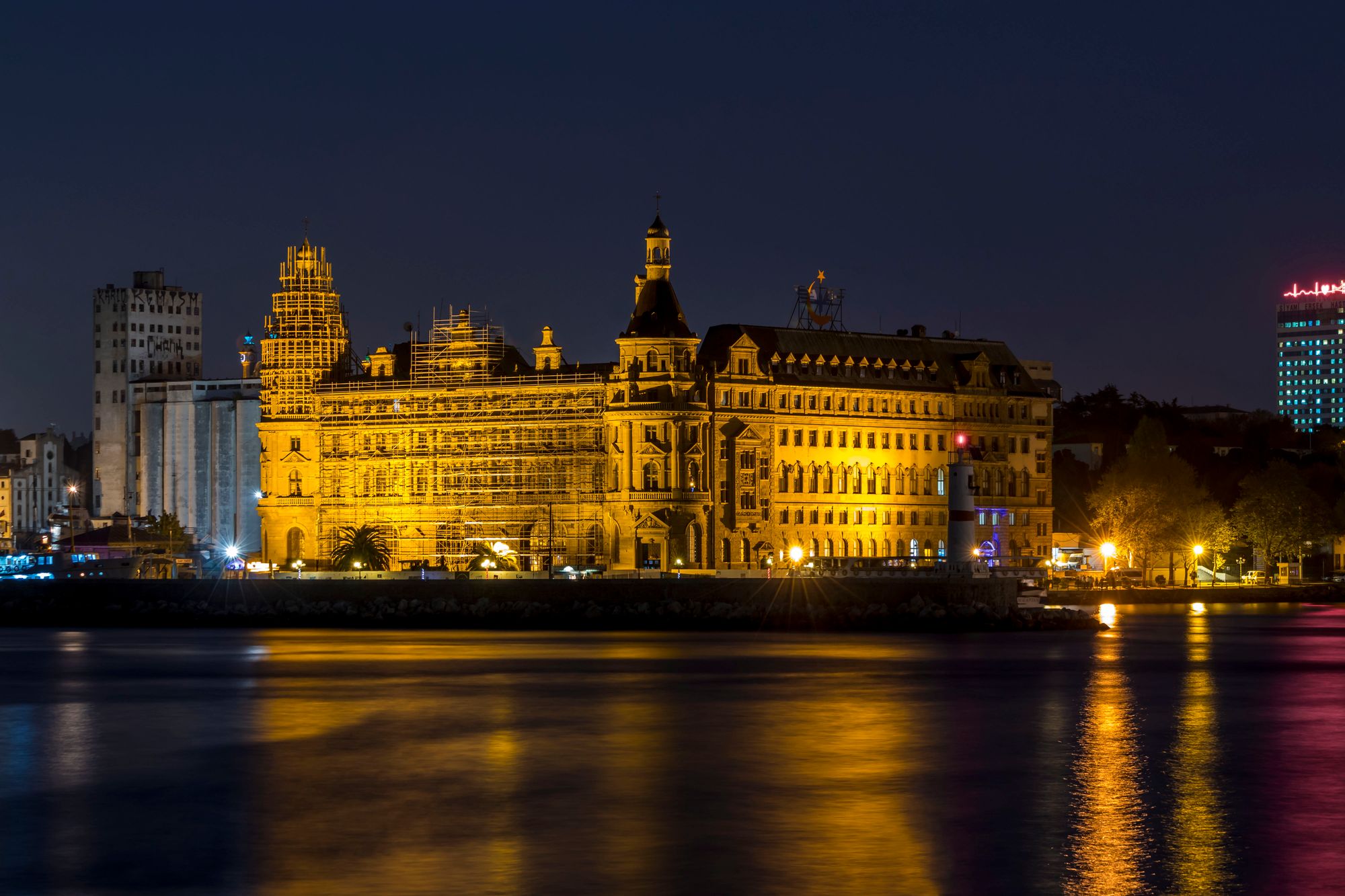 Gece ışıklandırılmış Haydarpaşa Garı ve suda yansıması